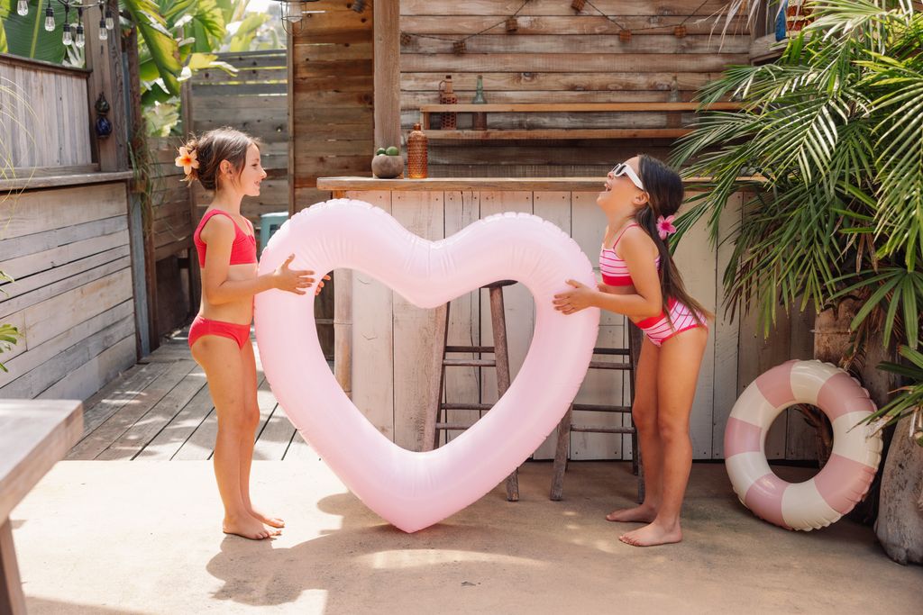 two girls holding heart swim toy
